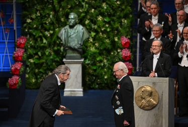 Король Швеції Карл XVI Густав (праворуч) нагороджує американського економіста Філіпа Дибвіга (ліворуч) премією Sveriges Riksbank з економічних наук пам’яті Альфреда Нобеля 2022. /Getty Images